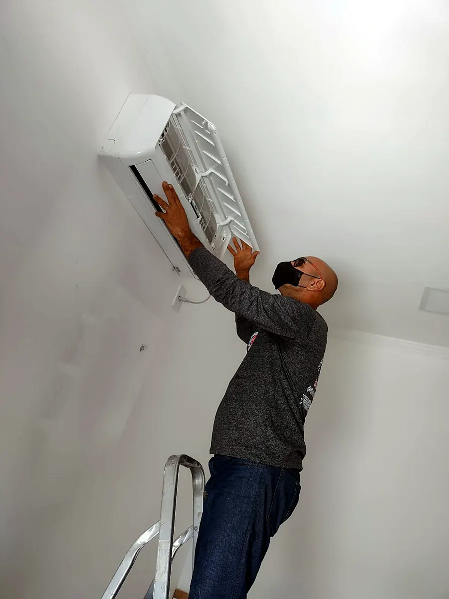Técnico instalando a unidade interna de um ar-condicionado